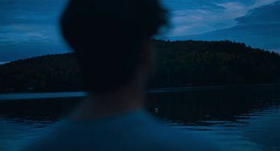 a man standing in front of a body of water