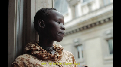 a woman standing next to a window with her eyes closed