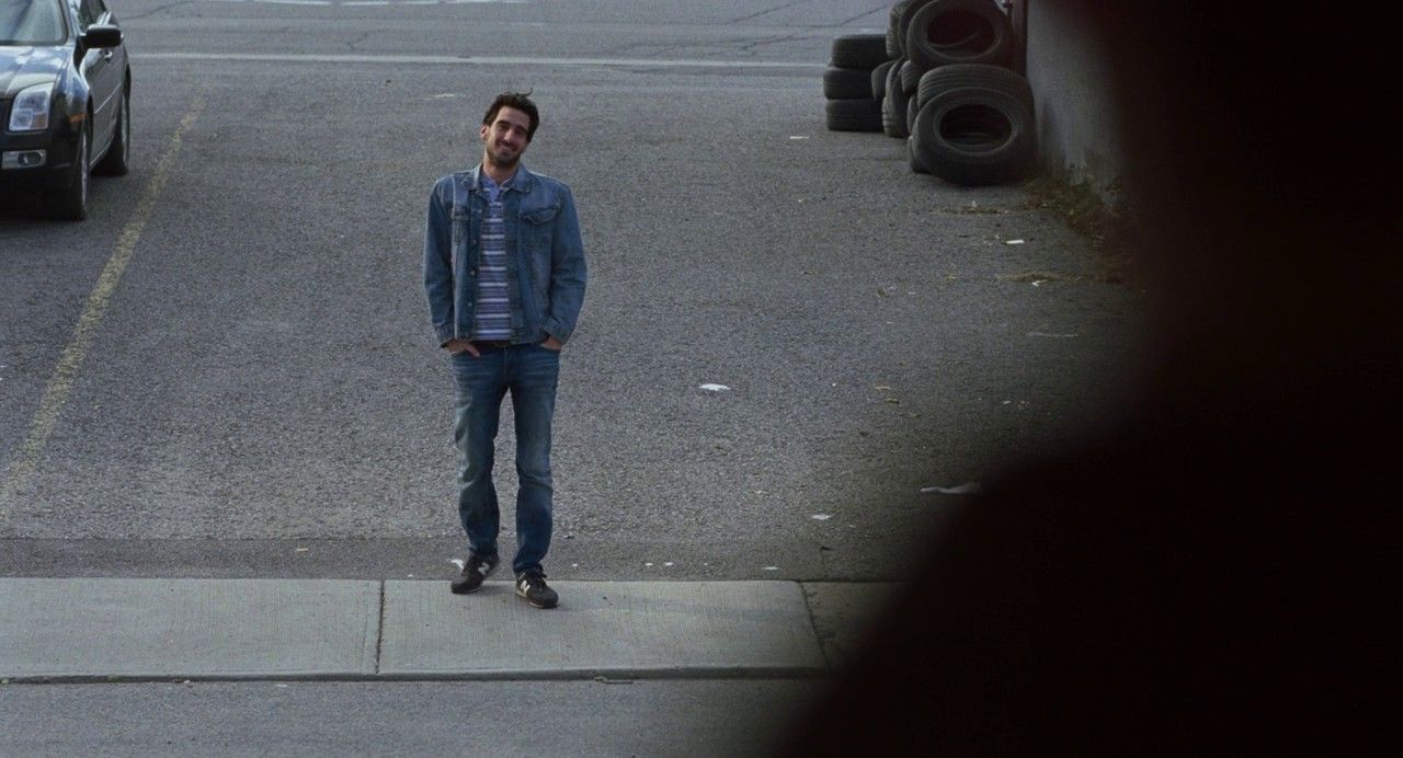 a man standing on a sidewalk next to a traffic light