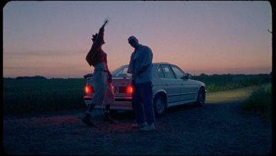 a couple of people standing next to a car