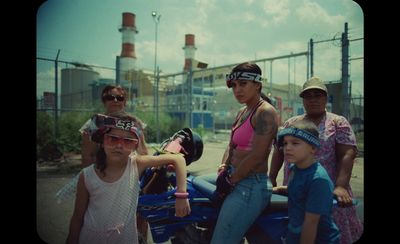 a group of people standing around a blue motorcycle