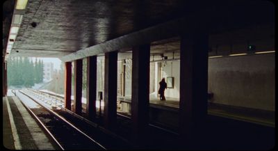 a train station with a person standing on the platform