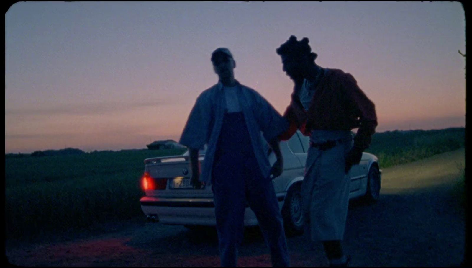 a couple of men standing next to a car