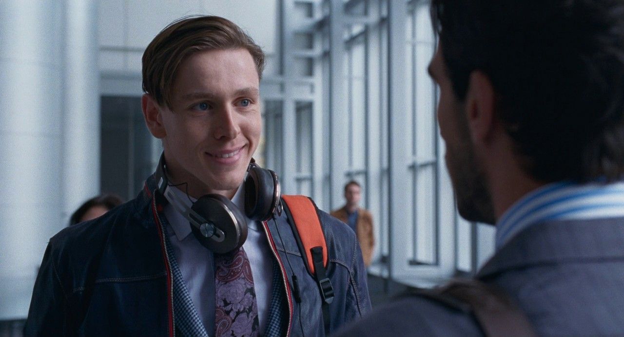 a man wearing headphones talking to another man