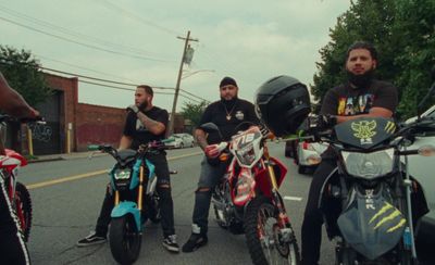 a group of men sitting on motorcycles on the side of the road