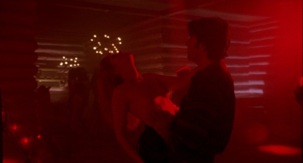 a man and a woman dancing in a dark room