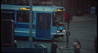 a blue bus driving down a street next to a traffic light