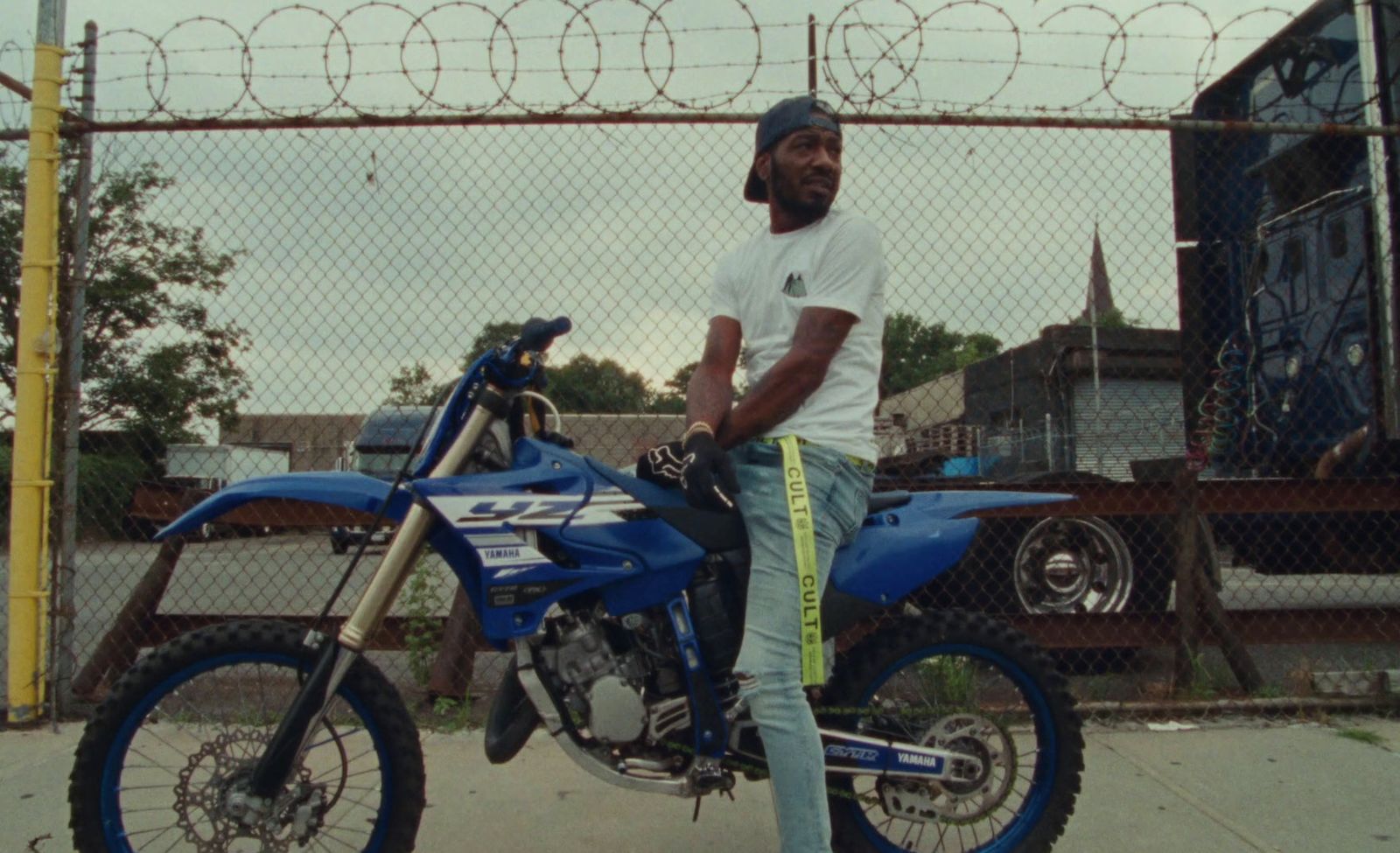 a man sitting on top of a blue dirt bike