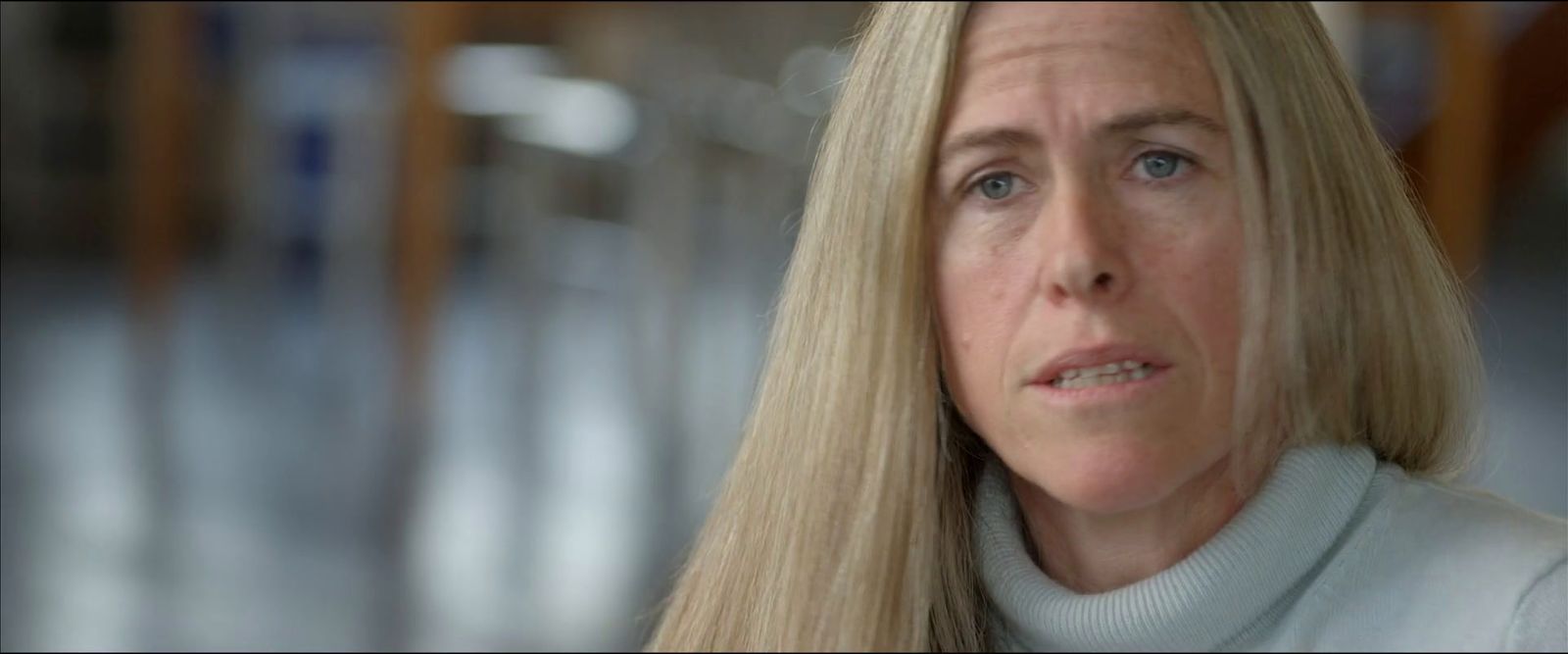 a woman with long blonde hair looking at the camera