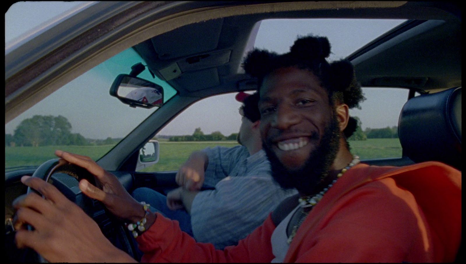 a man driving a car with a woman behind him