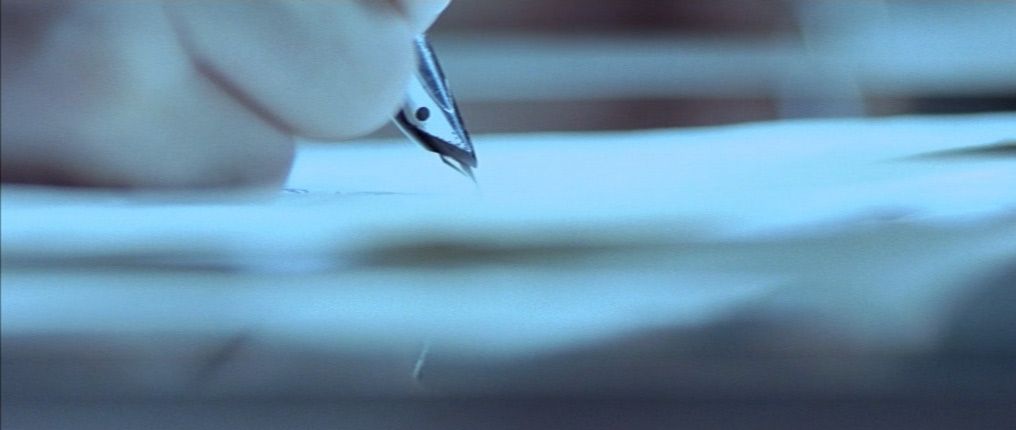 a person writing on a piece of paper with a pen