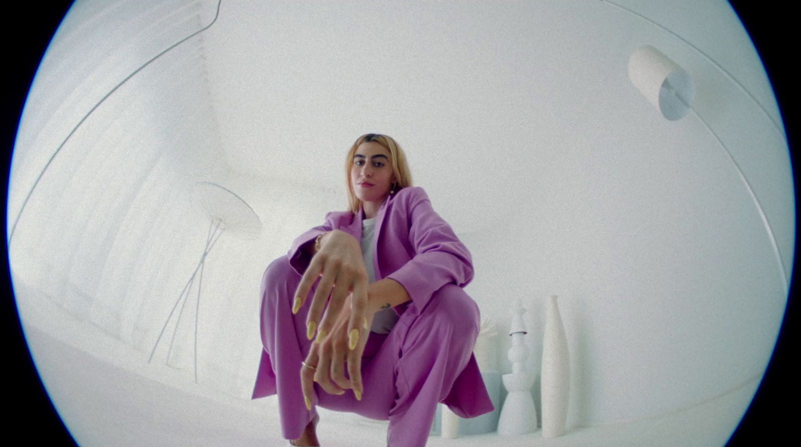 a woman in a purple outfit sitting on a white surface