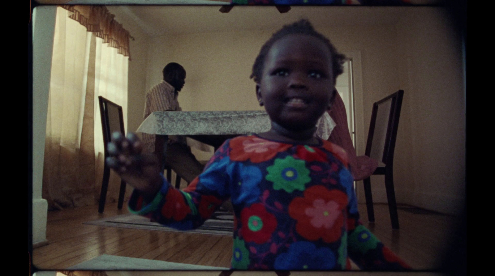 a little girl standing in front of a table