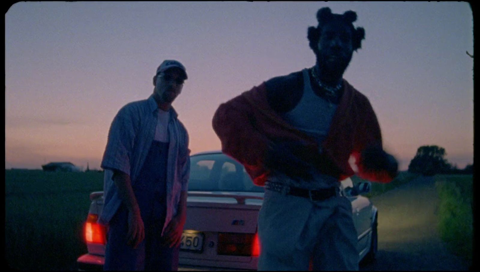 a couple of men standing next to a car