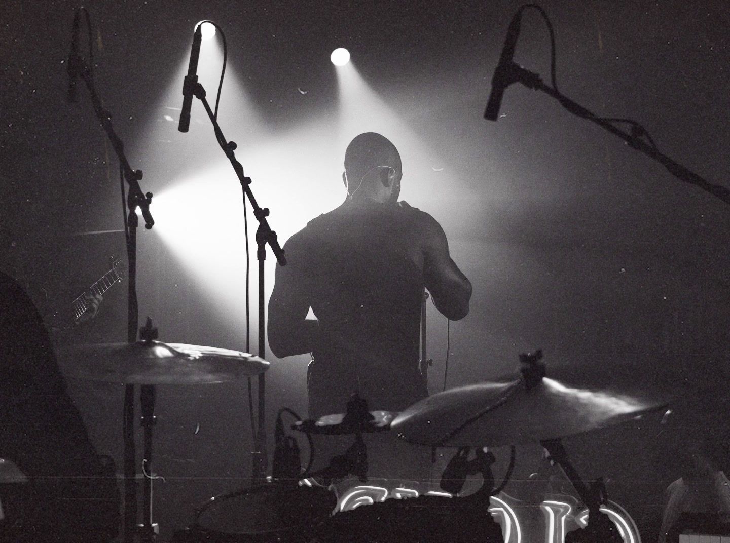 a man standing in front of a drum set