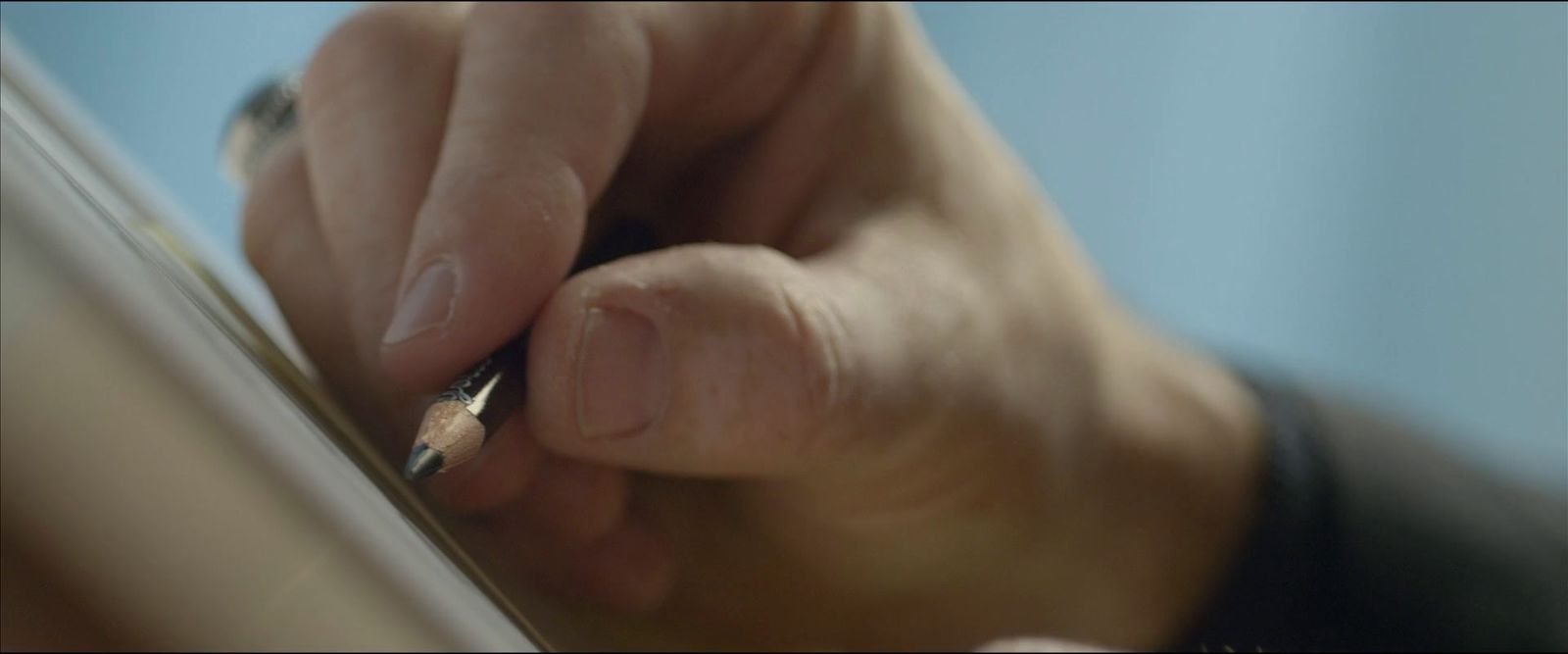 a person writing on a piece of paper with a pen