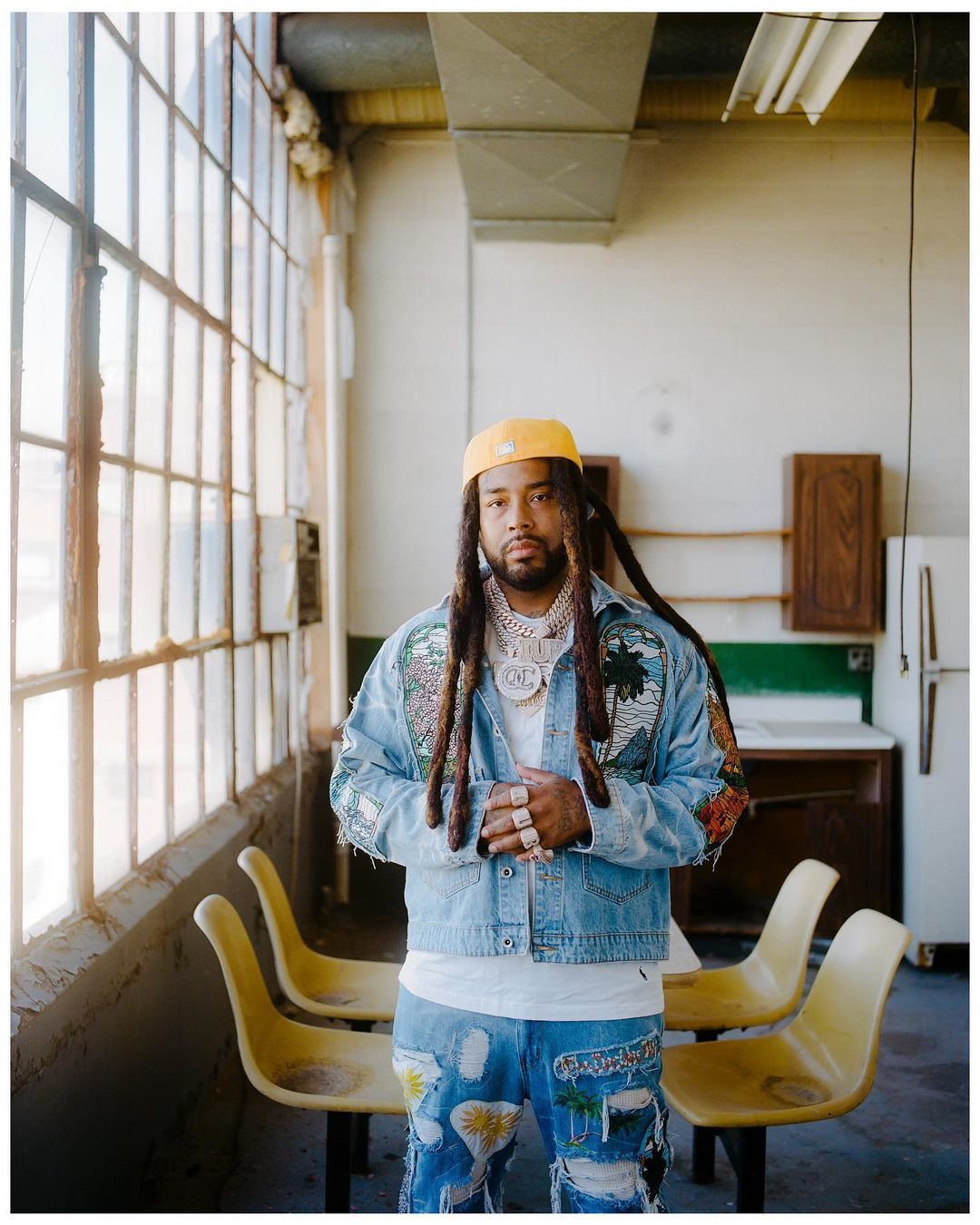 a man with dreadlocks standing in a room