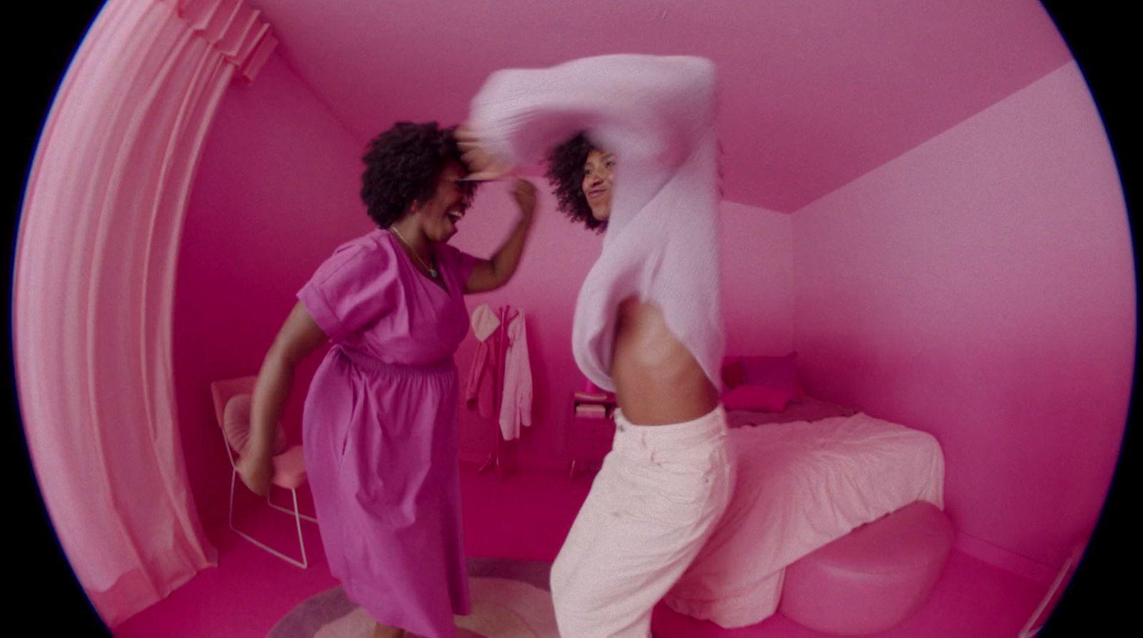 a couple of women standing in a pink room