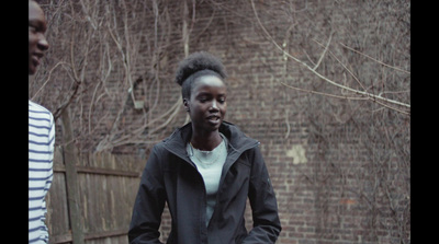 a woman standing in front of a brick wall