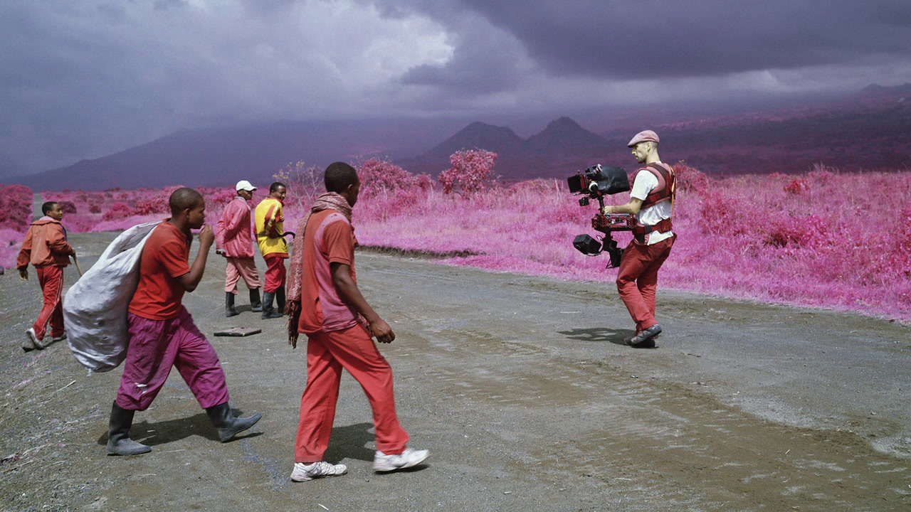 a group of people walking down a dirt road