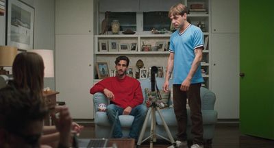 a man standing in a living room next to a woman