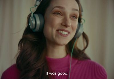 a woman wearing headphones with a smile on her face