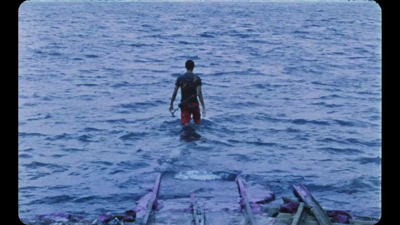 a man standing in the water on a surfboard