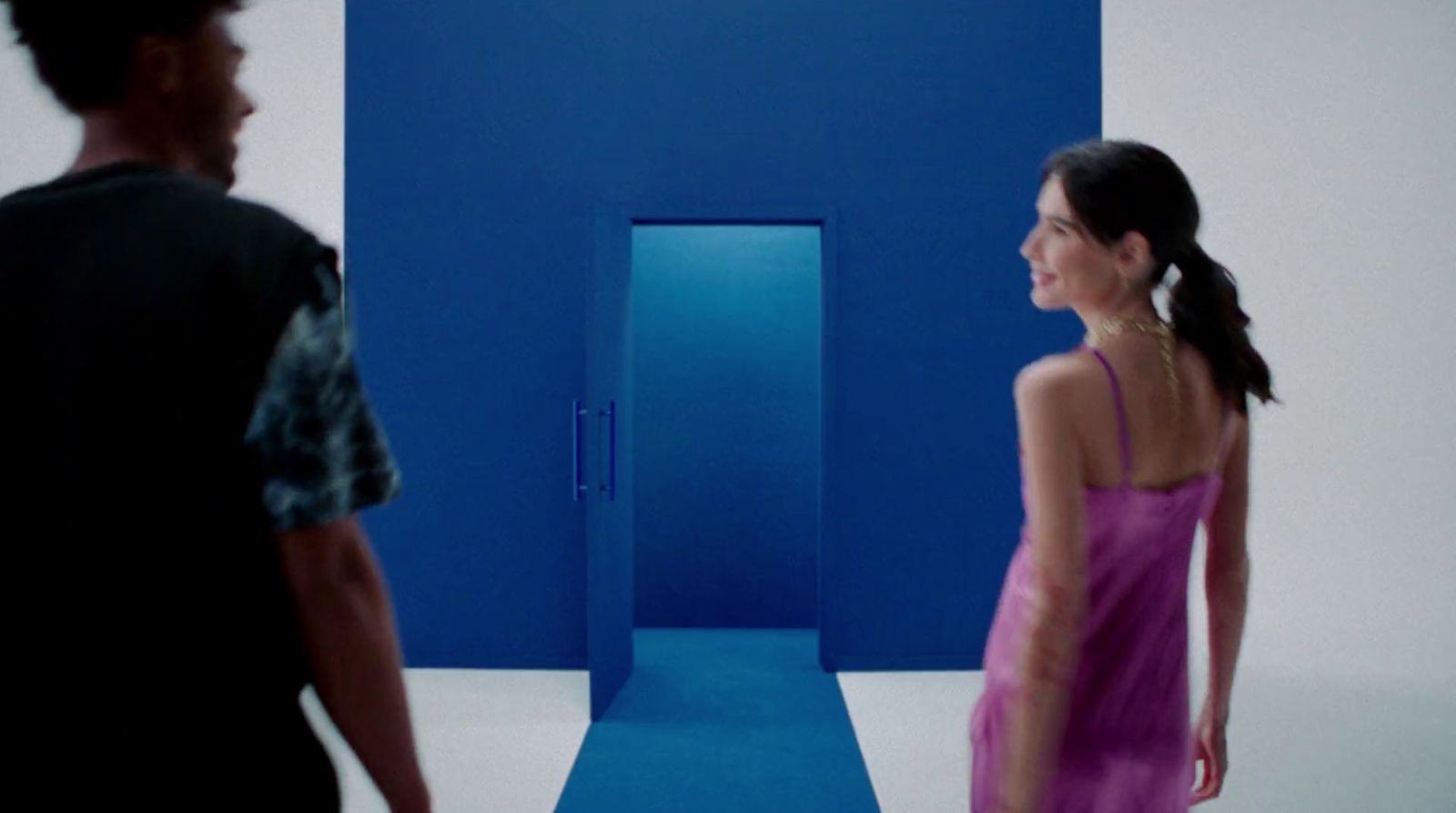 a man and a woman standing in front of a blue wall