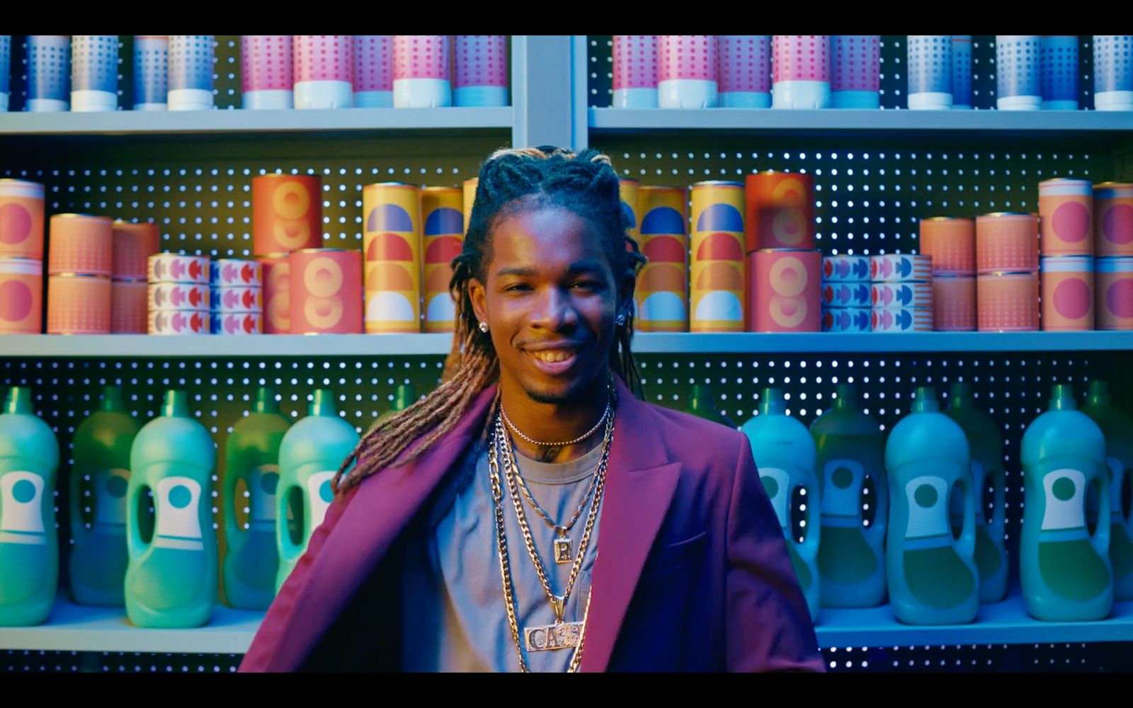 a man standing in front of a shelf of bottles