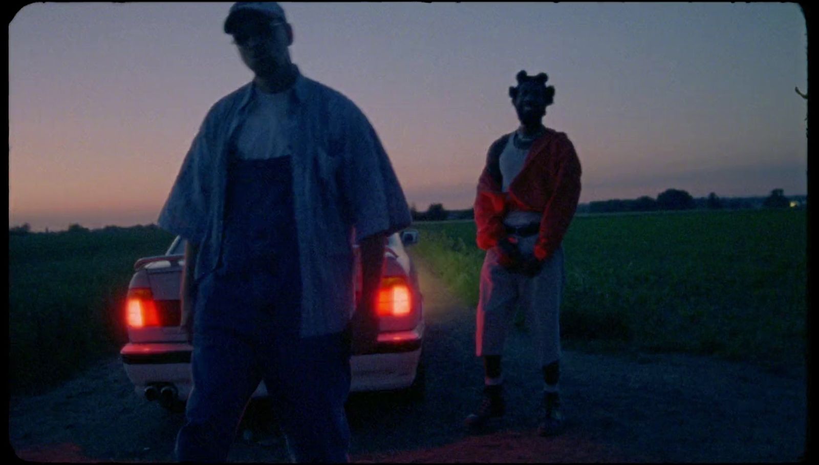 a couple of men standing next to a car