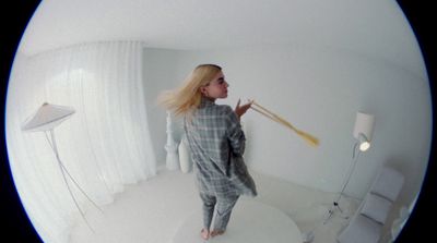 a woman standing in a room holding a broom