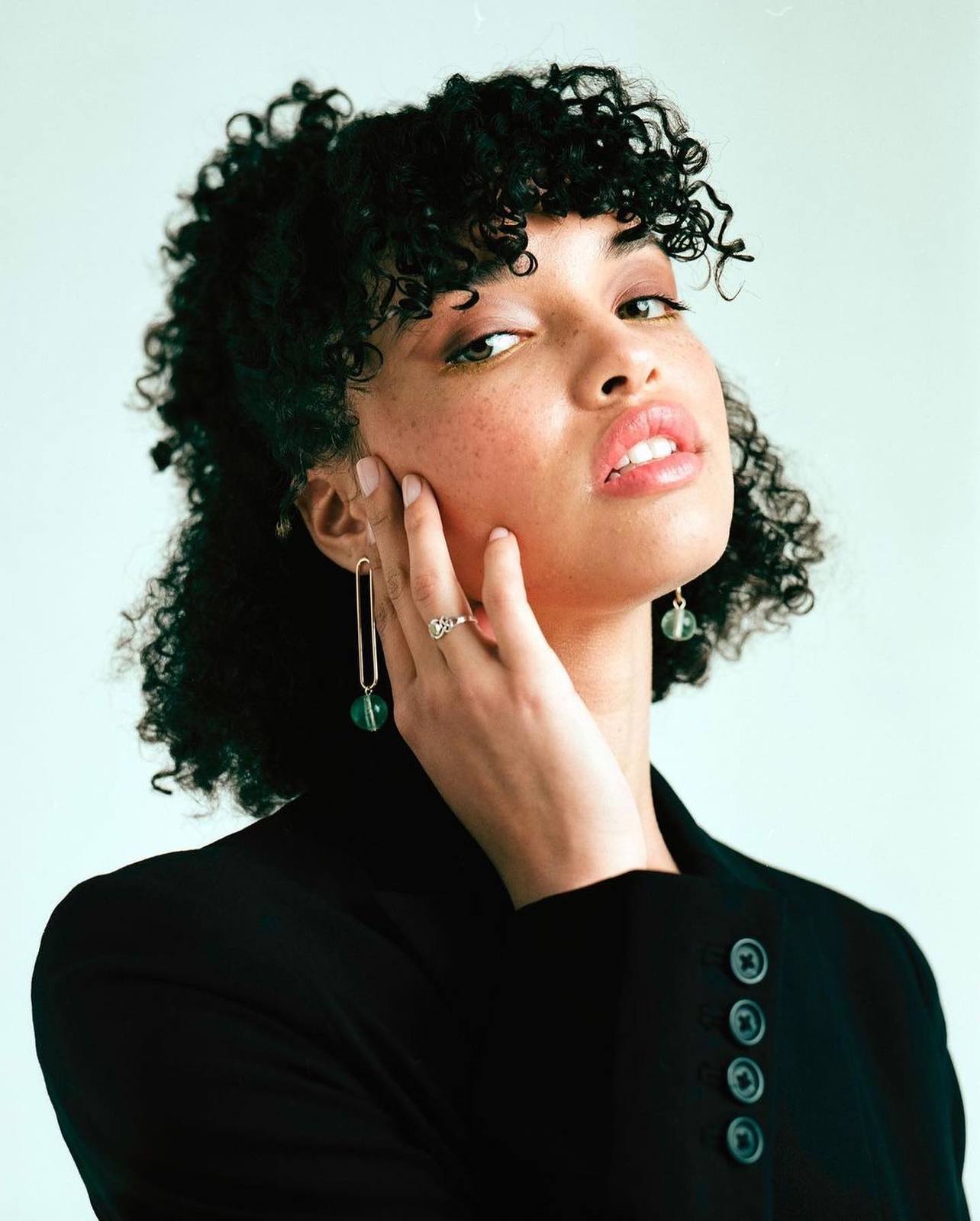 a woman with curly hair wearing a black shirt