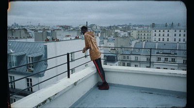 a man standing on top of a roof next to a tall building