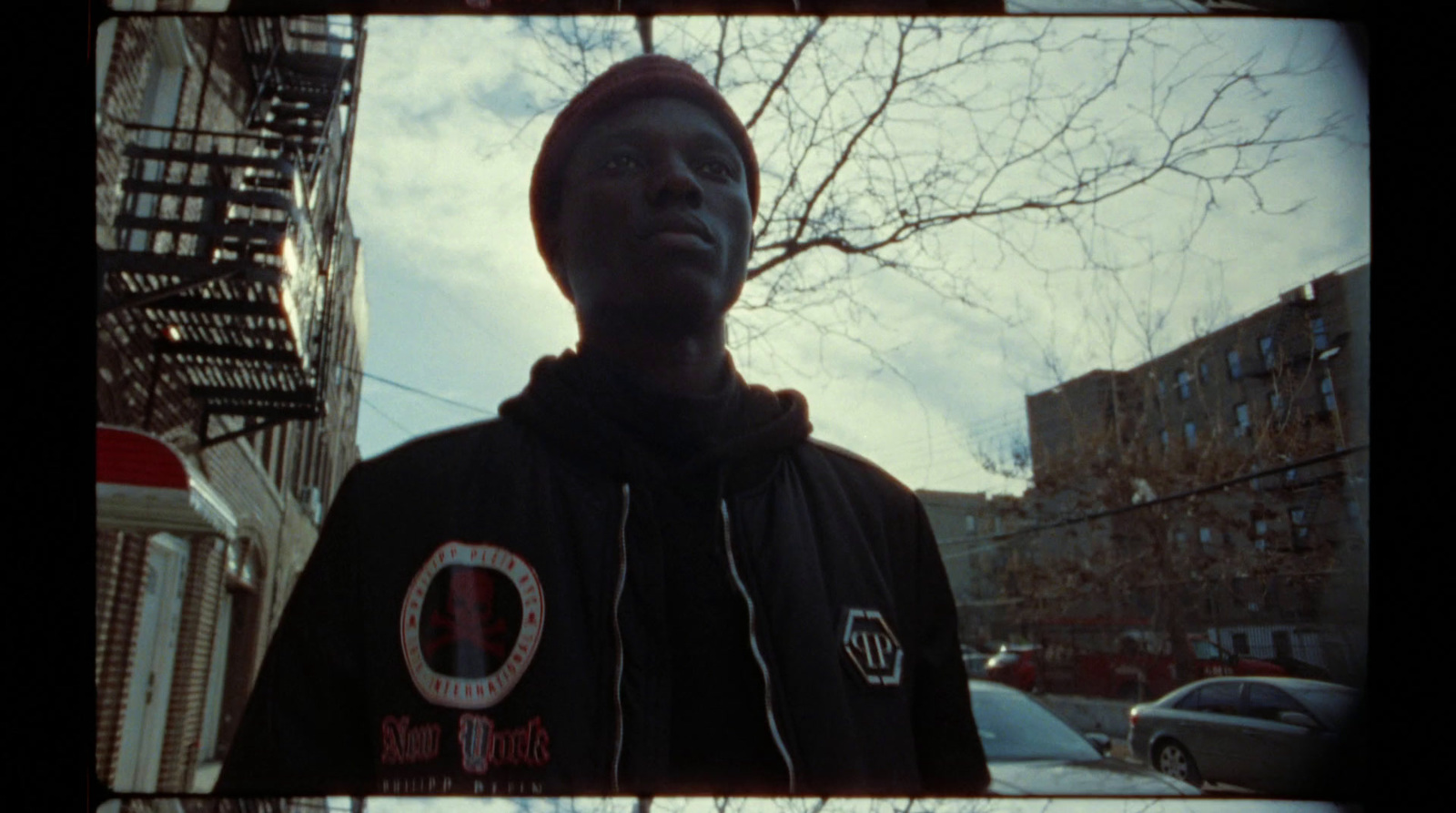 a man in a hoodie standing in front of a building