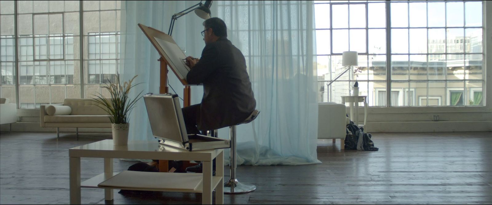 a man sitting at a desk in front of a window