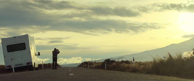 a person standing on the side of a road next to a trailer