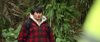 a young boy in a red and black plaid jacket