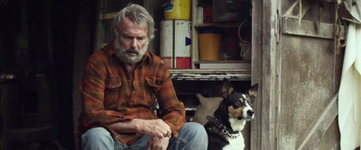 a man sitting in a doorway next to a dog