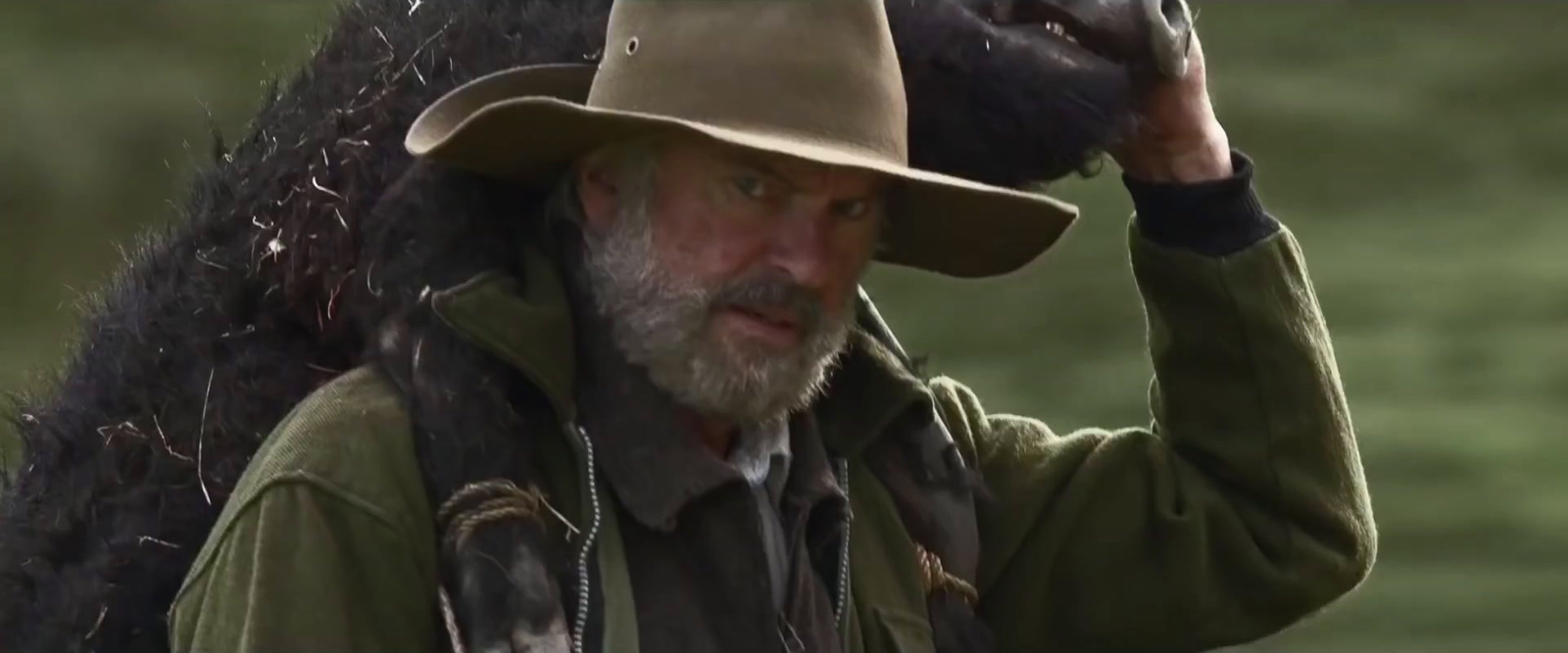 a man wearing a hat and holding a bird