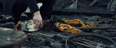 a person kneeling down in a burned out area