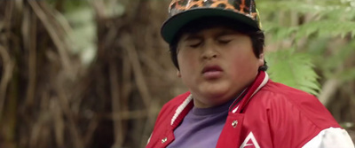 a young boy wearing a red jacket and a leopard print hat