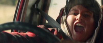 a woman is screaming while driving a car