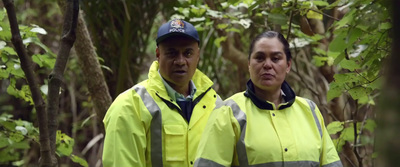 a couple of people standing in a forest