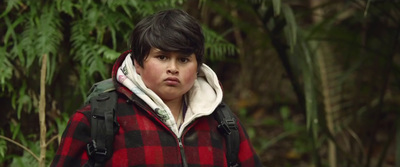 a young boy wearing a red and black plaid jacket