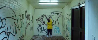 a person standing in a hallway with graffiti on the walls