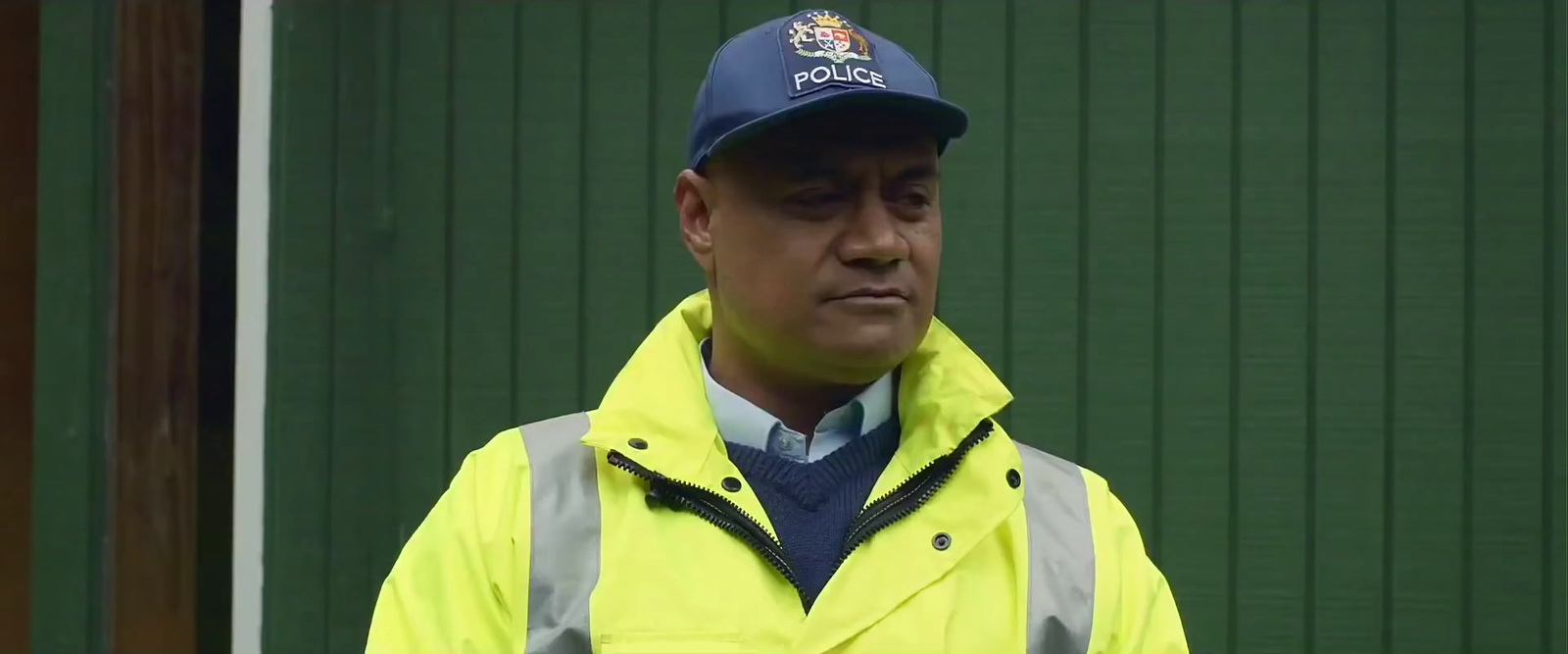 a man wearing a yellow jacket and a blue hat