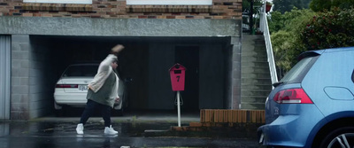 a person walking out of a garage with an umbrella