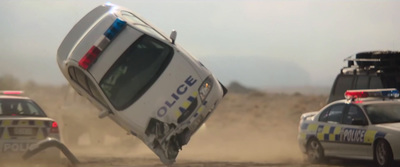 a police car that is upside down in the dirt