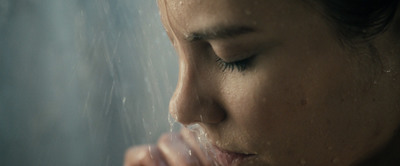 a close up of a woman's face with water coming out of her mouth