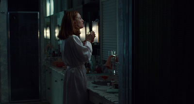 a woman standing in front of a mirror brushing her teeth